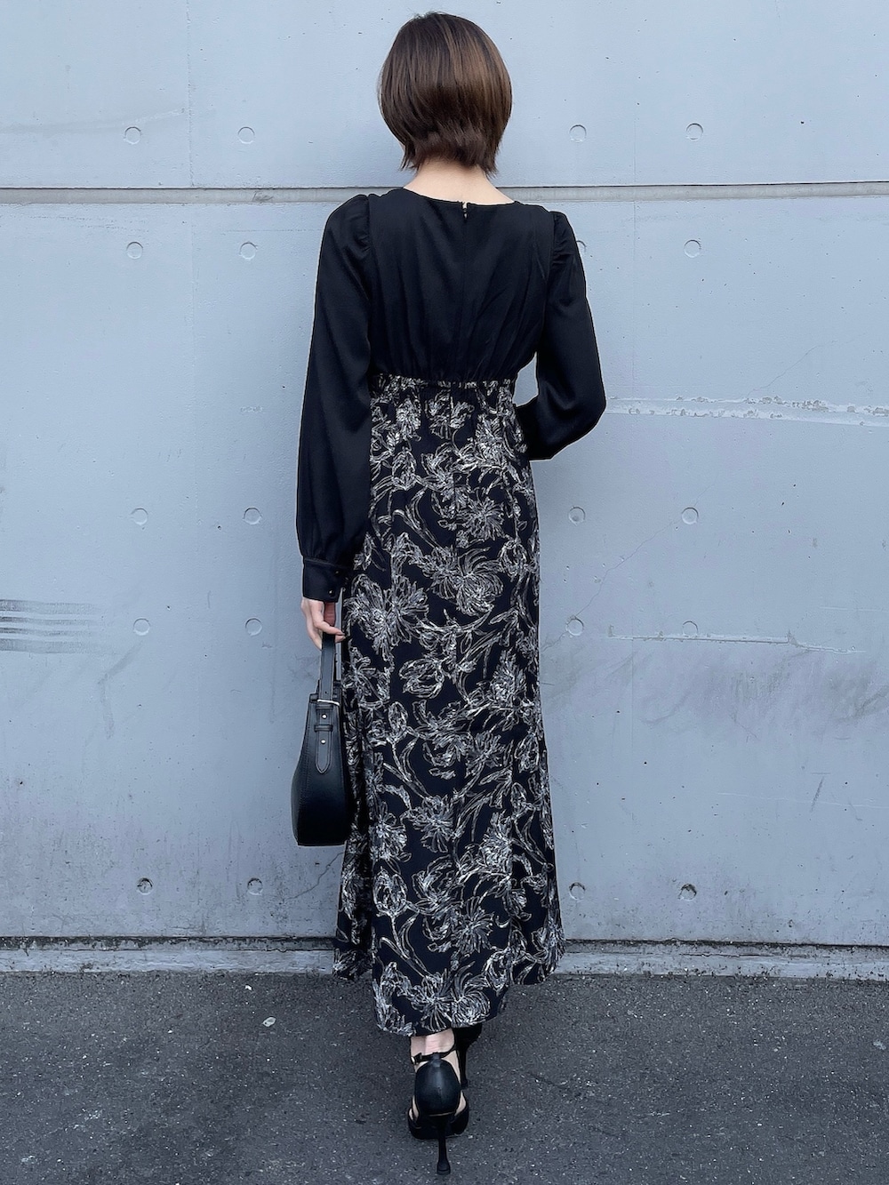 ベージュ系のトレンチコート、ブラック系のワンピース、ブラック系のハンドバッグを着用したレディースの冬コーディネートの3枚目の写真