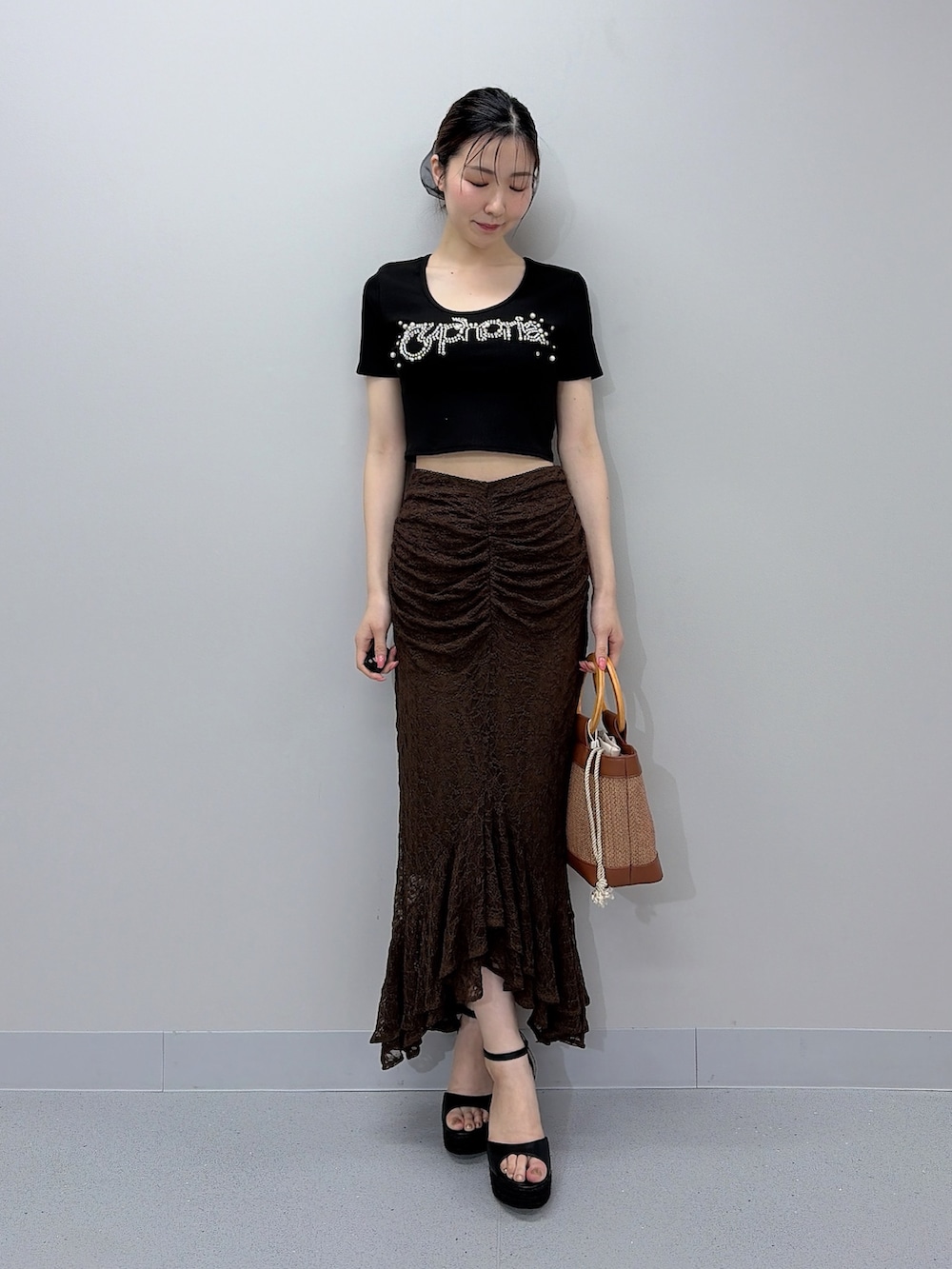 ブラック系のTシャツ/カットソー、ブラウン系のスカート、ブラウン系のハンドバッグを着用したレディースの夏コーディネートの2枚目の写真