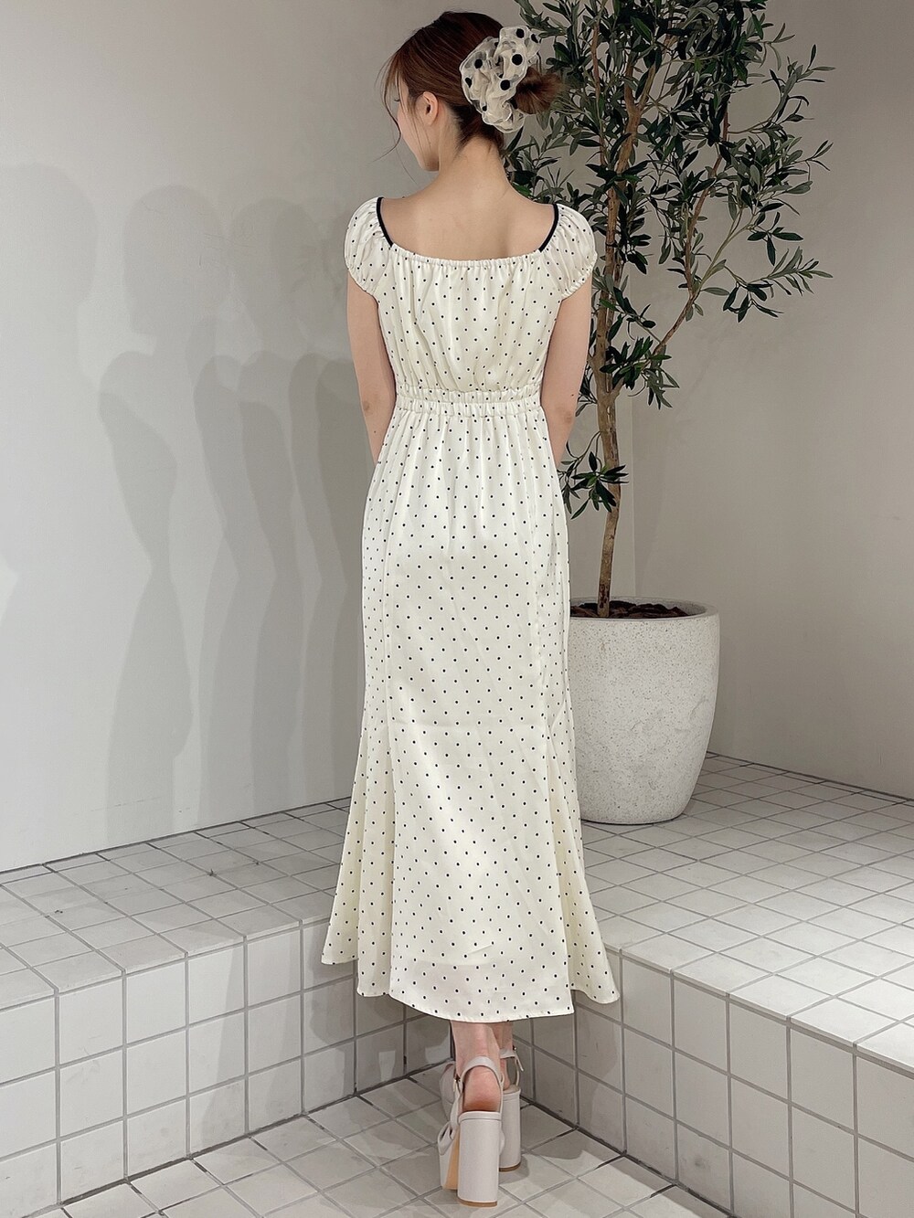 ホワイト系のワンピース、ベージュ系のサンダル、ベージュ系のシュシュを着用したレディースの春コーディネートの3枚目の写真