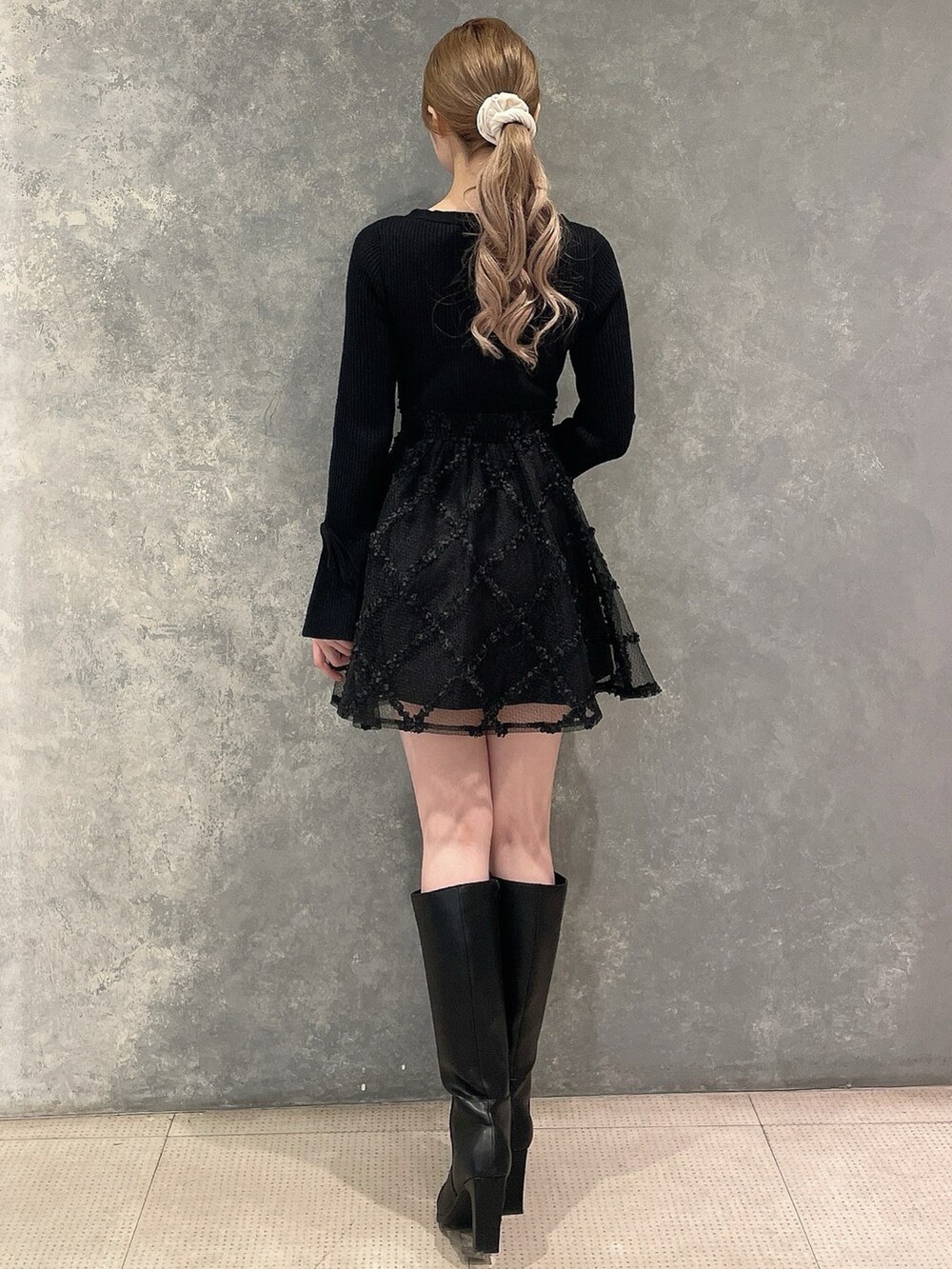 グレー系のその他アウター、ブラック系のワンピース、ブラック系のブーツを着用したレディースの秋コーディネートの6枚目の写真
