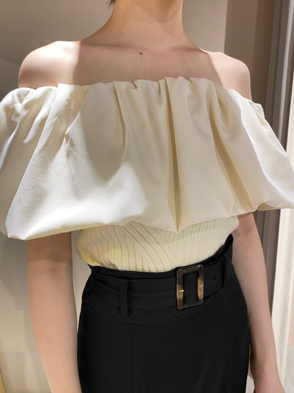 ホワイト系のニット/セーター、ブルー系のスカート、ホワイト系のパンプスを着用したレディースの春コーディネートの4枚目の写真