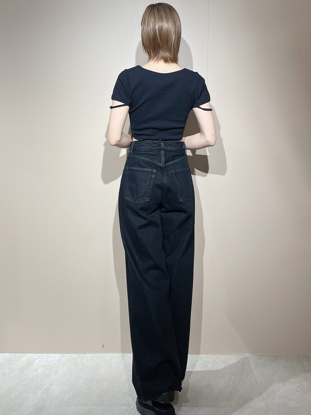 ブラック系のTシャツ/カットソー、ブラック系のデニムパンツ、ブラック系のサンダルを着用したレディースの春コーディネートの4枚目の写真