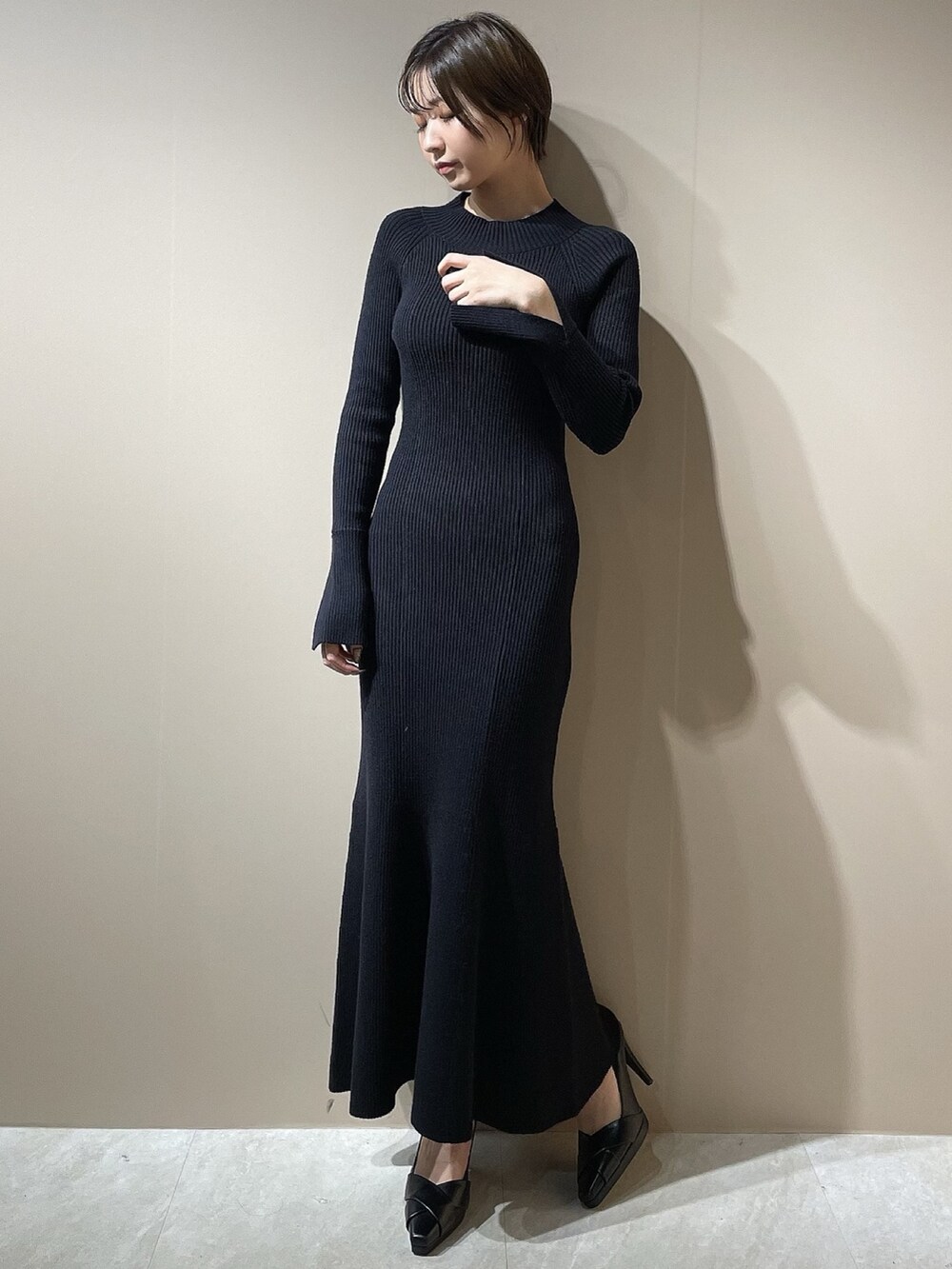 ブラック系のダウンジャケット/コート、ブラック系のワンピース、ブラック系のパンプスを着用したレディースの秋コーディネートの8枚目の写真