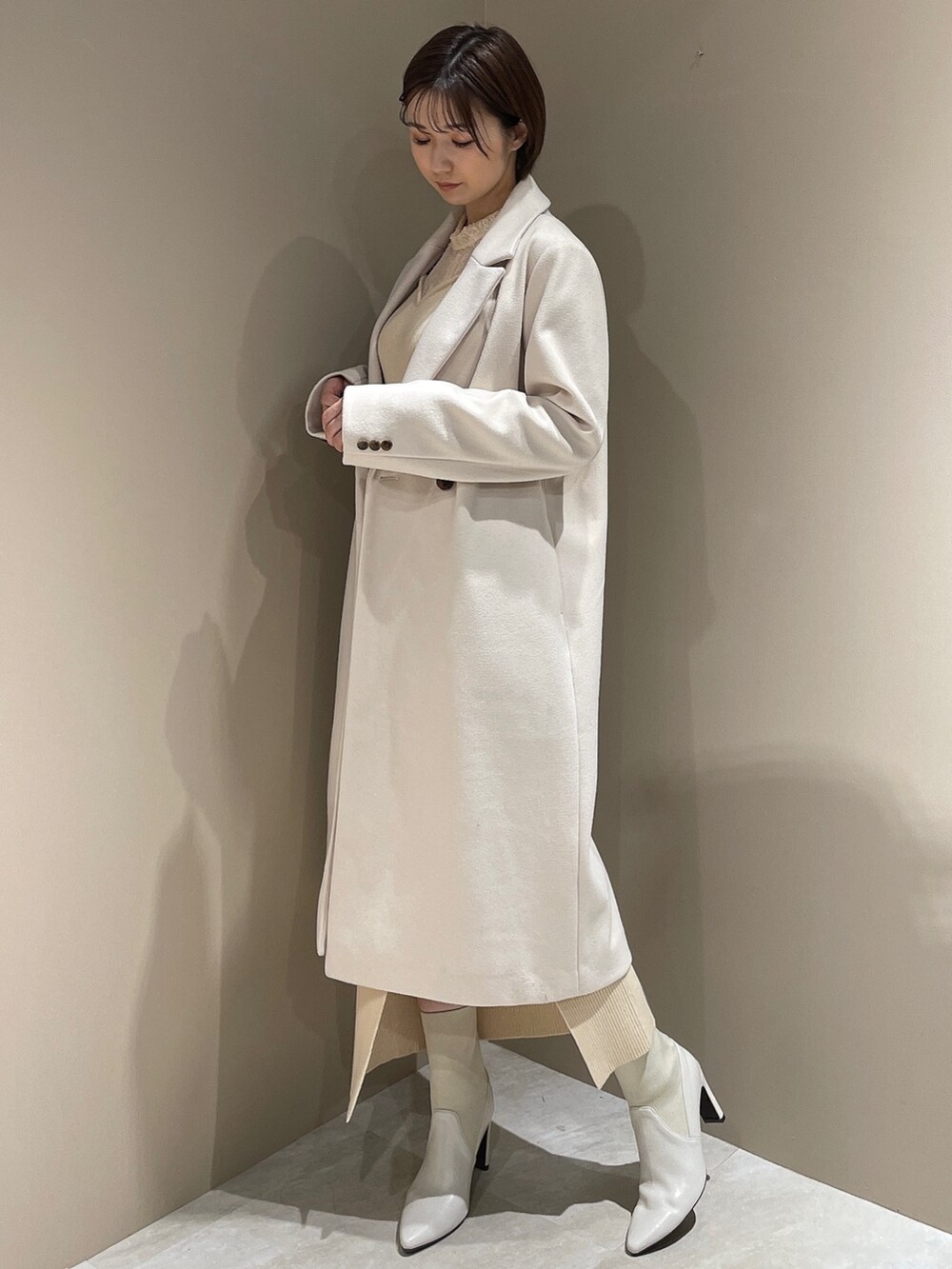 ホワイト系のチェスターコート、ホワイト系のブーツ、ホワイト系のワンピースを着用したレディースの夏コーディネートの3枚目の写真