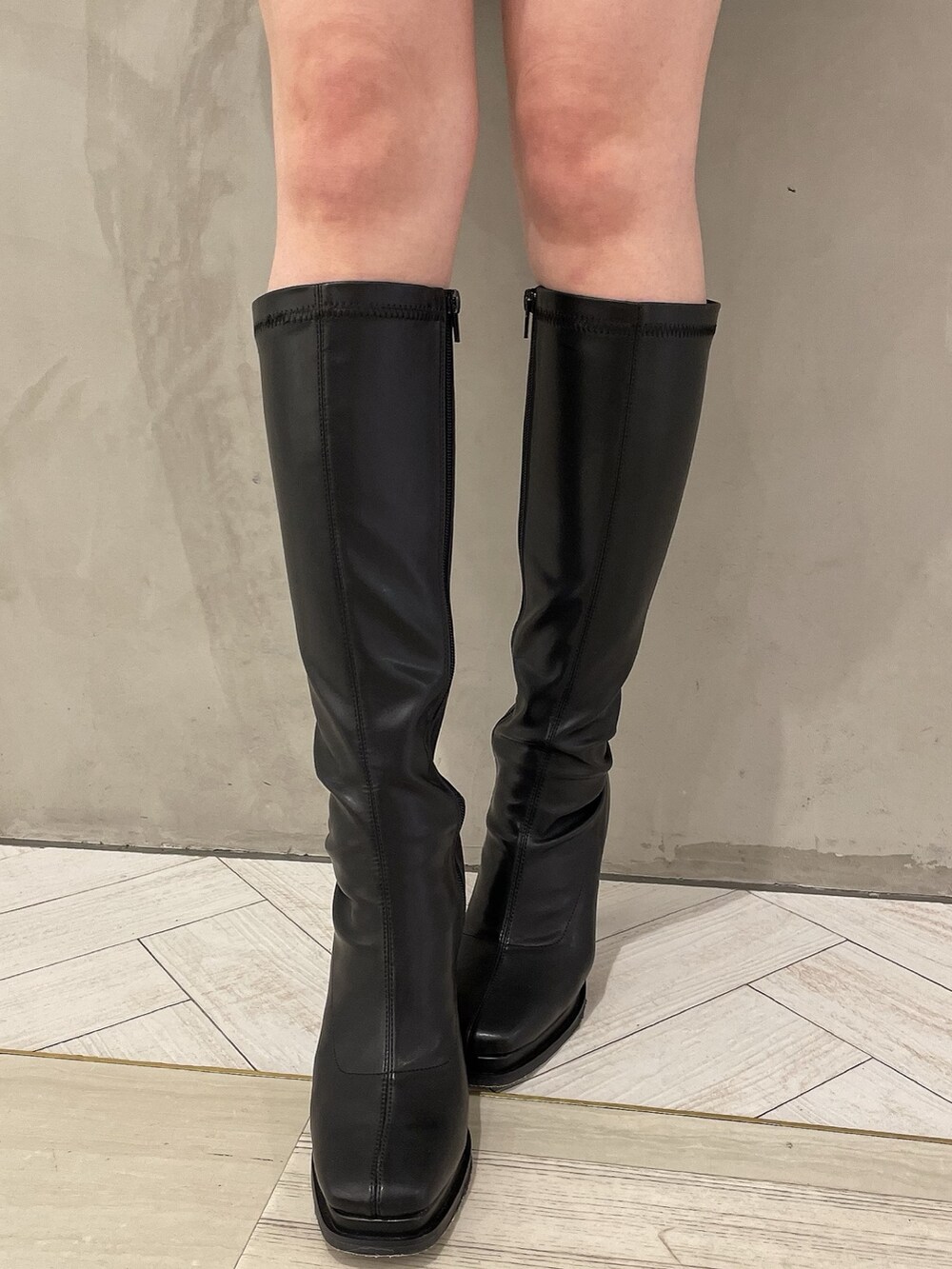 ブラック系のハンドバッグ、ブラック系のブーツ、ブルー系のワンピースを着用したレディースの冬コーディネートの8枚目の写真