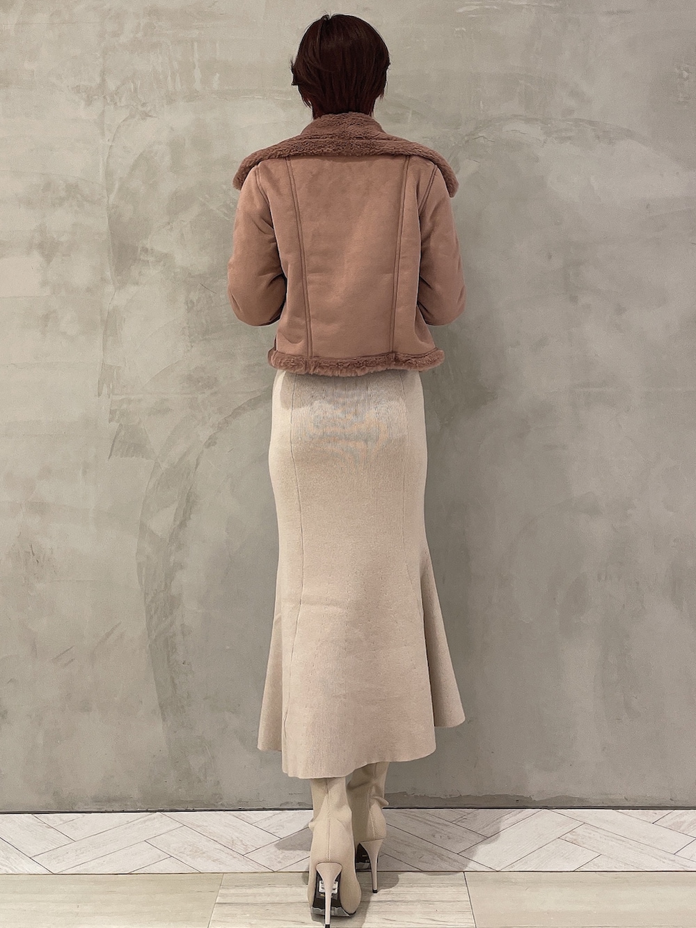 ホワイト系のブーツ、ピンク系のブルゾン、ホワイト系のワンピースを着用したレディースの冬コーディネートの2枚目の写真