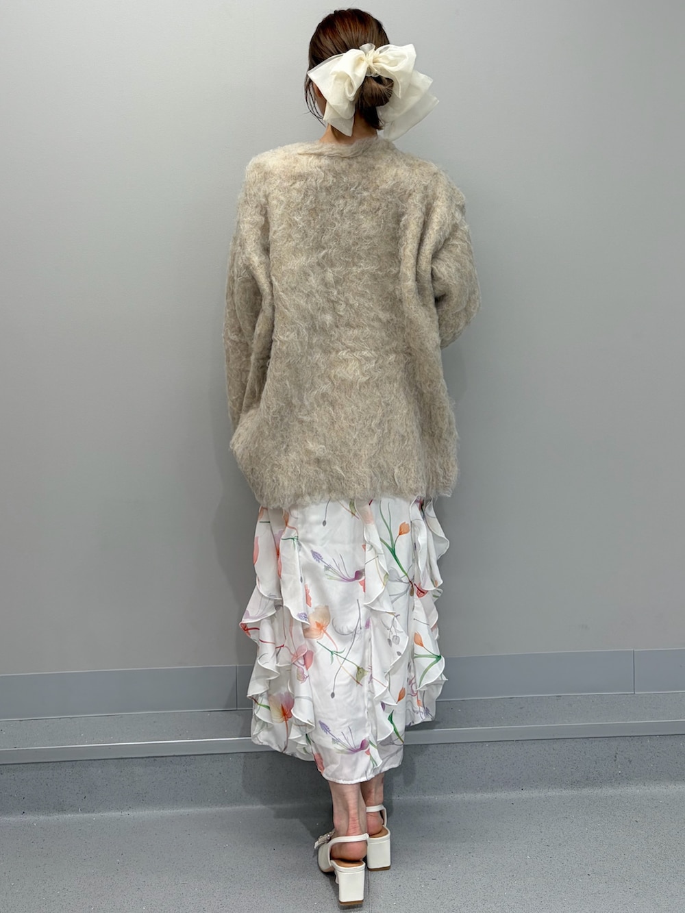 ベージュ系のカーディガン/ボレロ、ホワイト系のワンピース、ホワイト系のパンプスを着用したレディースの冬コーディネートの4枚目の写真