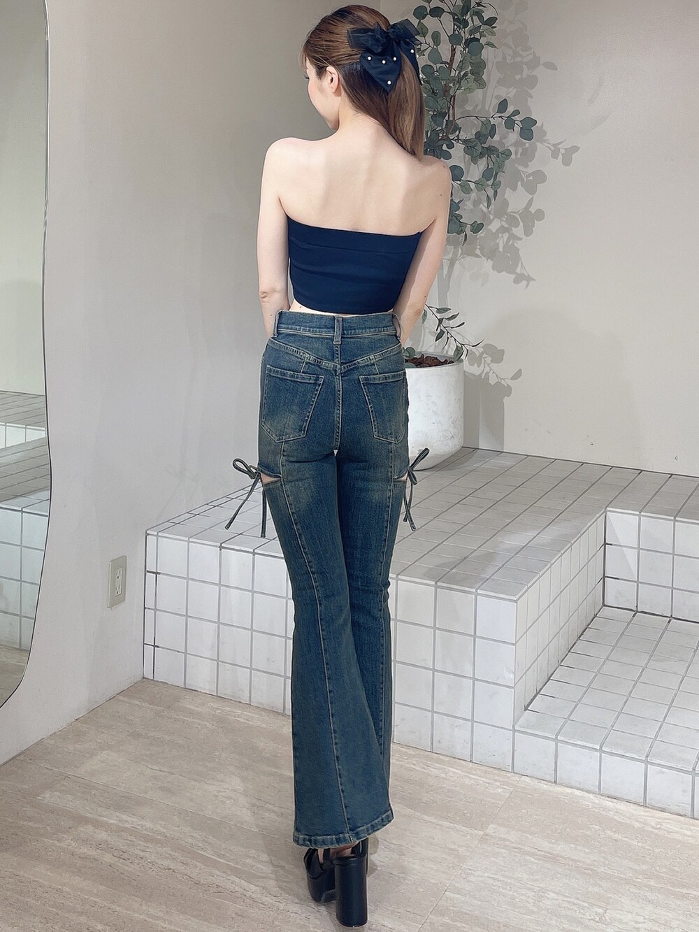 ブラック系のキャミソール、ブルー系のデニムパンツ、ブラック系のサンダルを着用したレディースの夏コーディネートの4枚目の写真