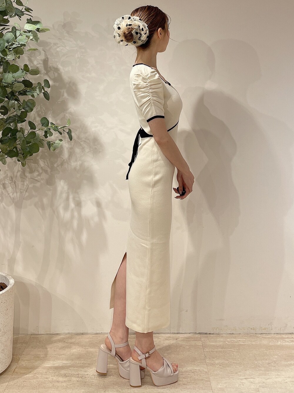 ホワイト系のライダースジャケット、ホワイト系のワンピース、ベージュ系のサンダルを着用したレディースの春コーディネートの6枚目の写真