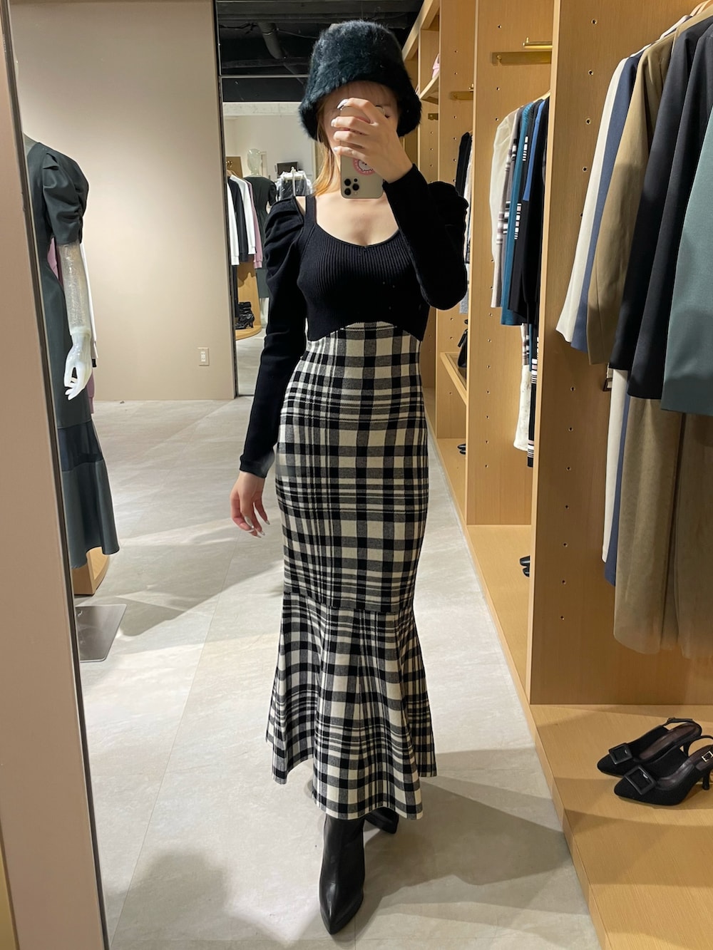 ブラック系のワンピース、ブラック系のブーツ、ブラック系のハットを着用したレディースの秋コーディネートの4枚目の写真