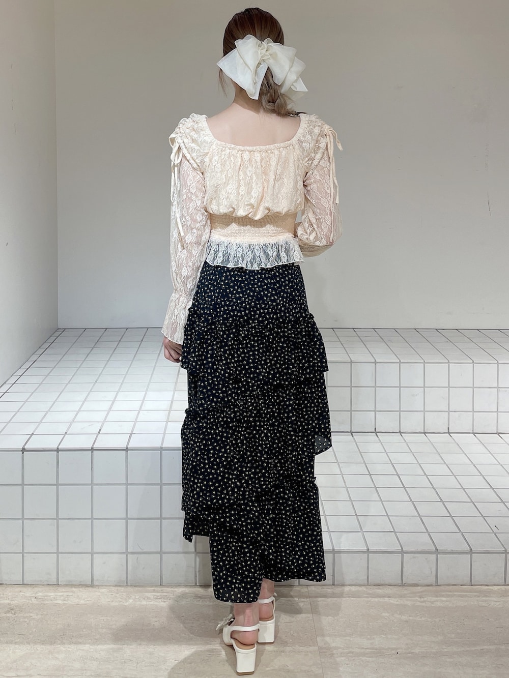 オレンジ系のシャツ/ブラウス、ブラック系のスカート、ホワイト系のパンプスを着用したレディースの春コーディネートの5枚目の写真