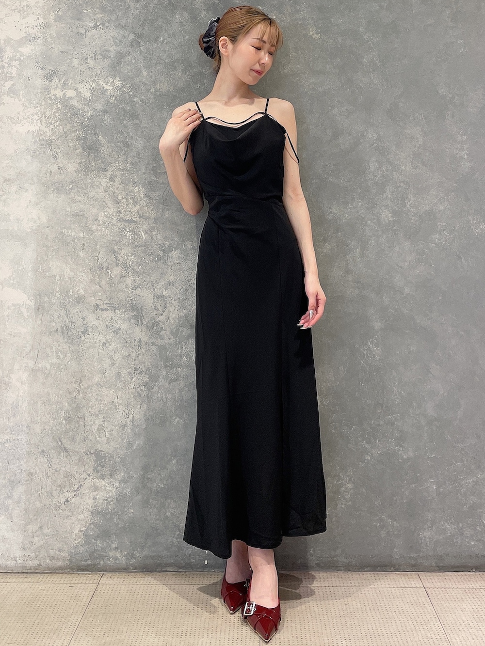 ブラック系のワンピース、レッド系のパンプス、グレー系のシュシュを着用したレディースの夏コーディネートの2枚目の写真