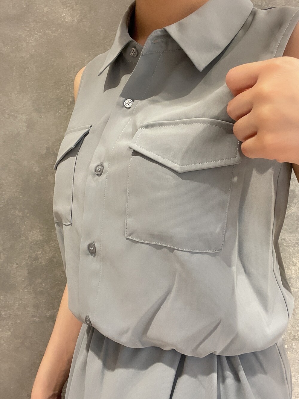 ホワイト系のハンドバッグ、ホワイト系のサンダル、ブルー系のシャツワンピースを着用したレディースの夏コーディネートの5枚目の写真