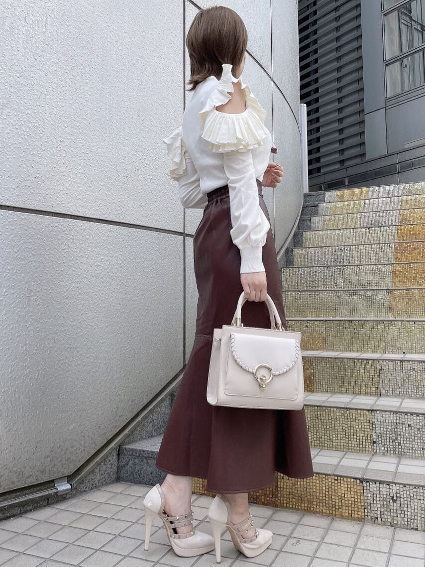 ホワイト系のハンドバッグ、ベージュ系のパンプス、ホワイト系のニット/セーターを着用したレディースの秋コーディネートの4枚目の写真