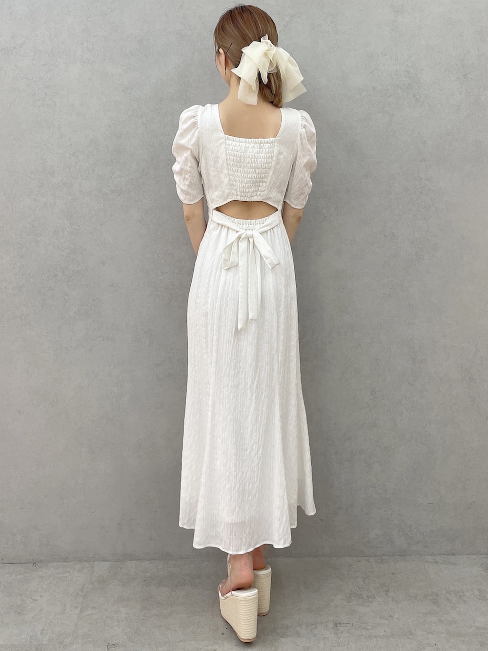 ホワイト系のワンピース、ホワイト系のサンダル、ホワイト系のバレッタ/ヘアクリップを着用したレディースの春コーディネートの3枚目の写真