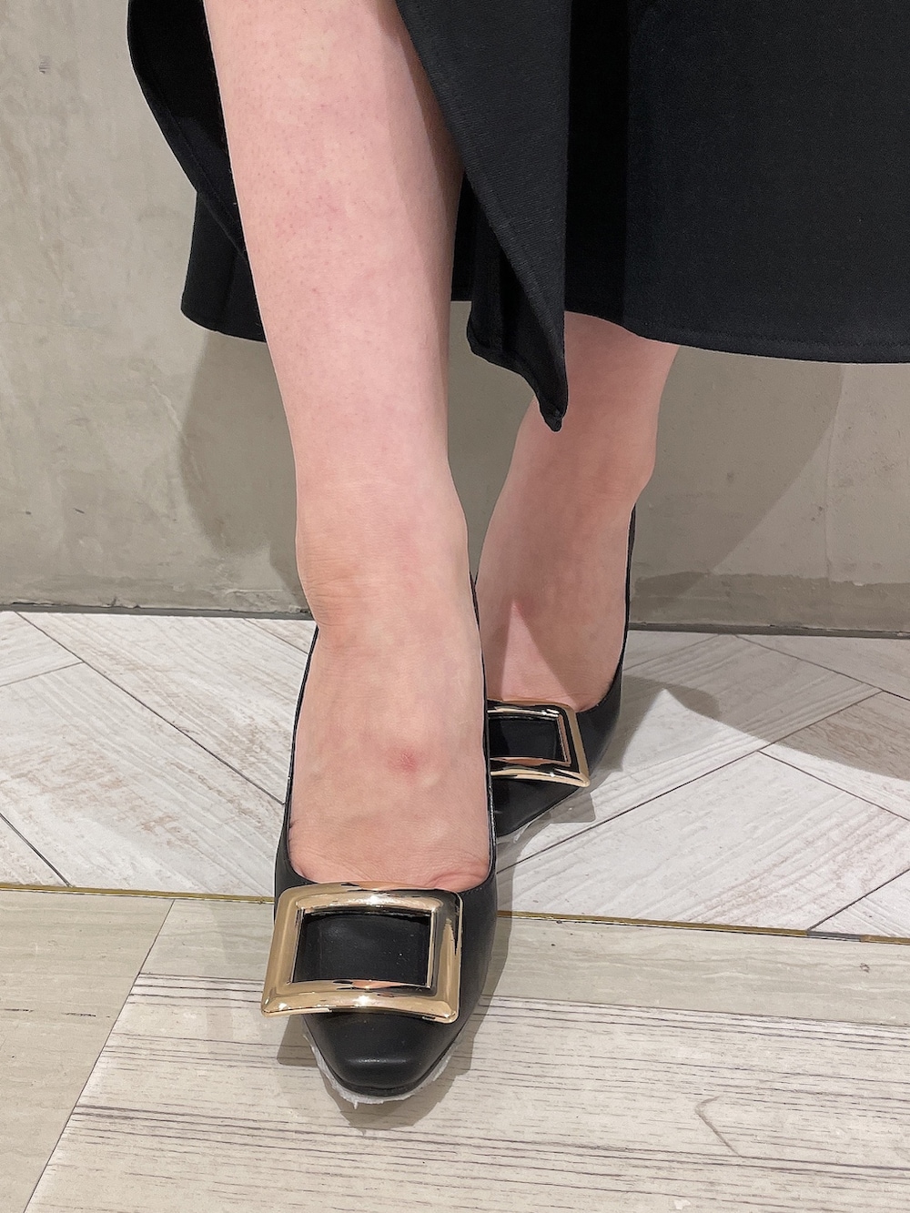 ホワイト系のニット/セーター、ブラック系のスカート、ブラック系のパンプスを着用したレディースの春コーディネートの7枚目の写真