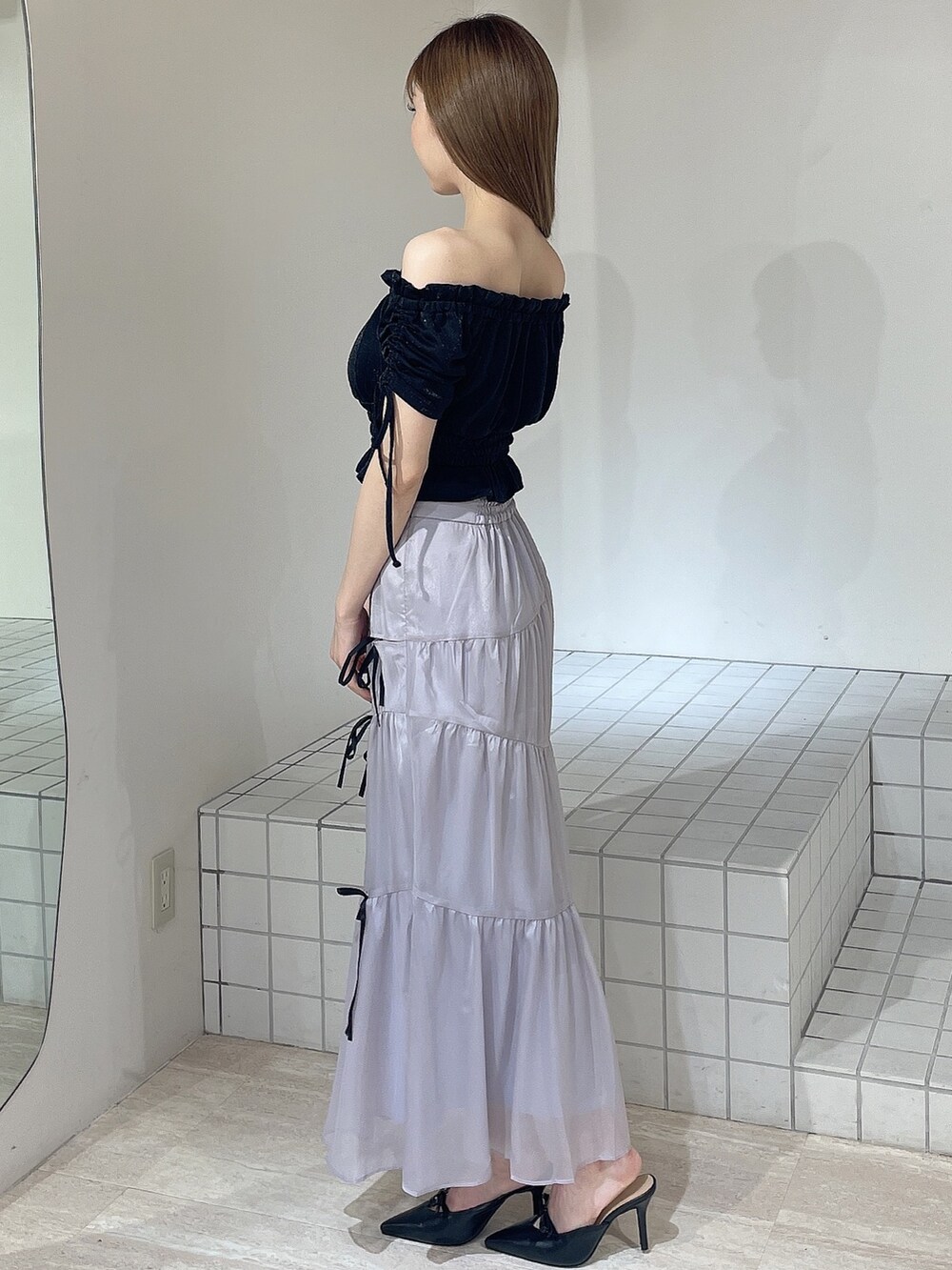 ブラック系のTシャツ/カットソー、ブルー系のスカート、ブラック系のパンプスを着用したレディースの夏コーディネートの2枚目の写真