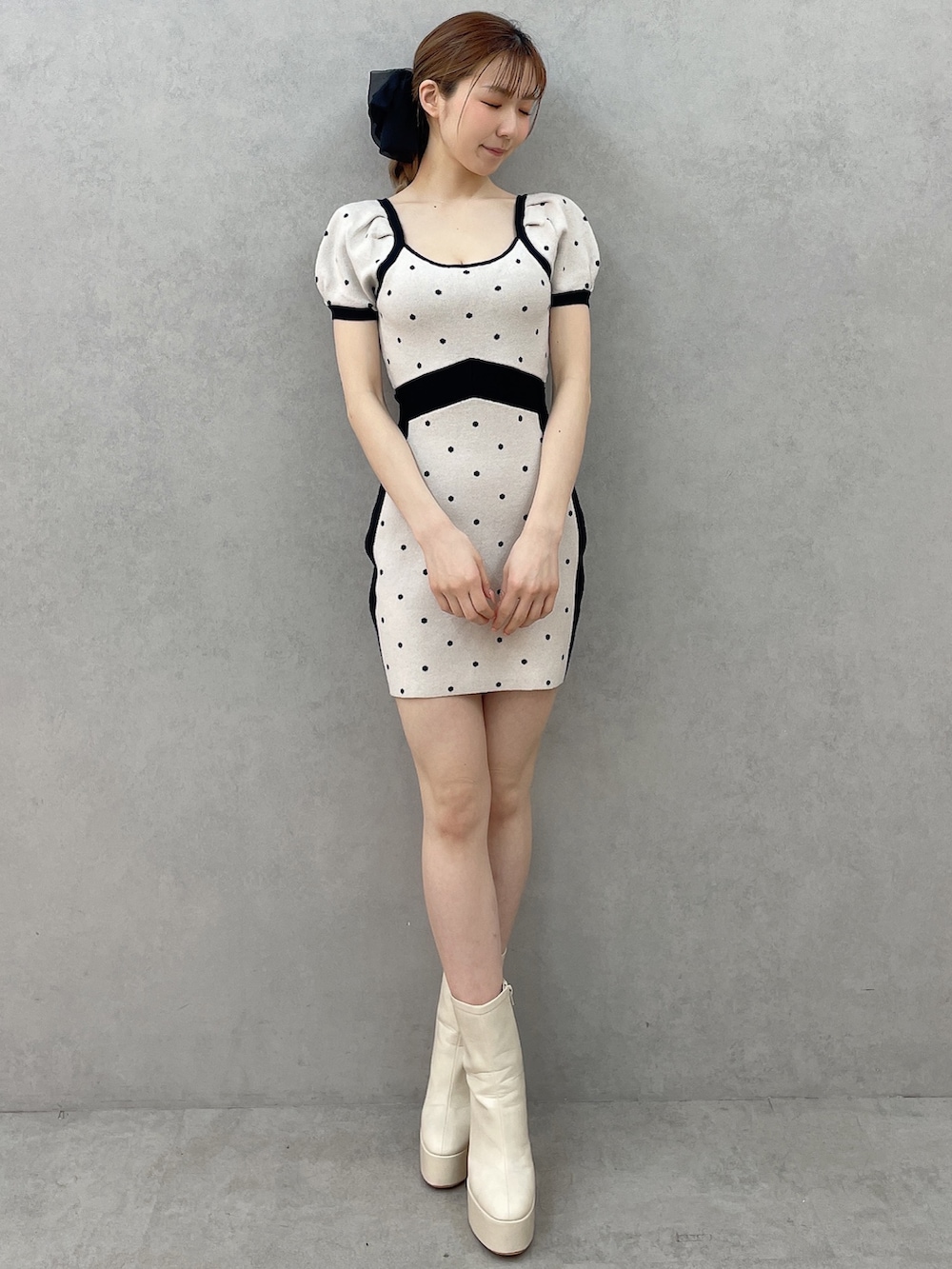 ブラック系のワンピース、ホワイト系のブーツ、ブラック系のバレッタ/ヘアクリップを着用したレディースの春コーディネートの2枚目の写真