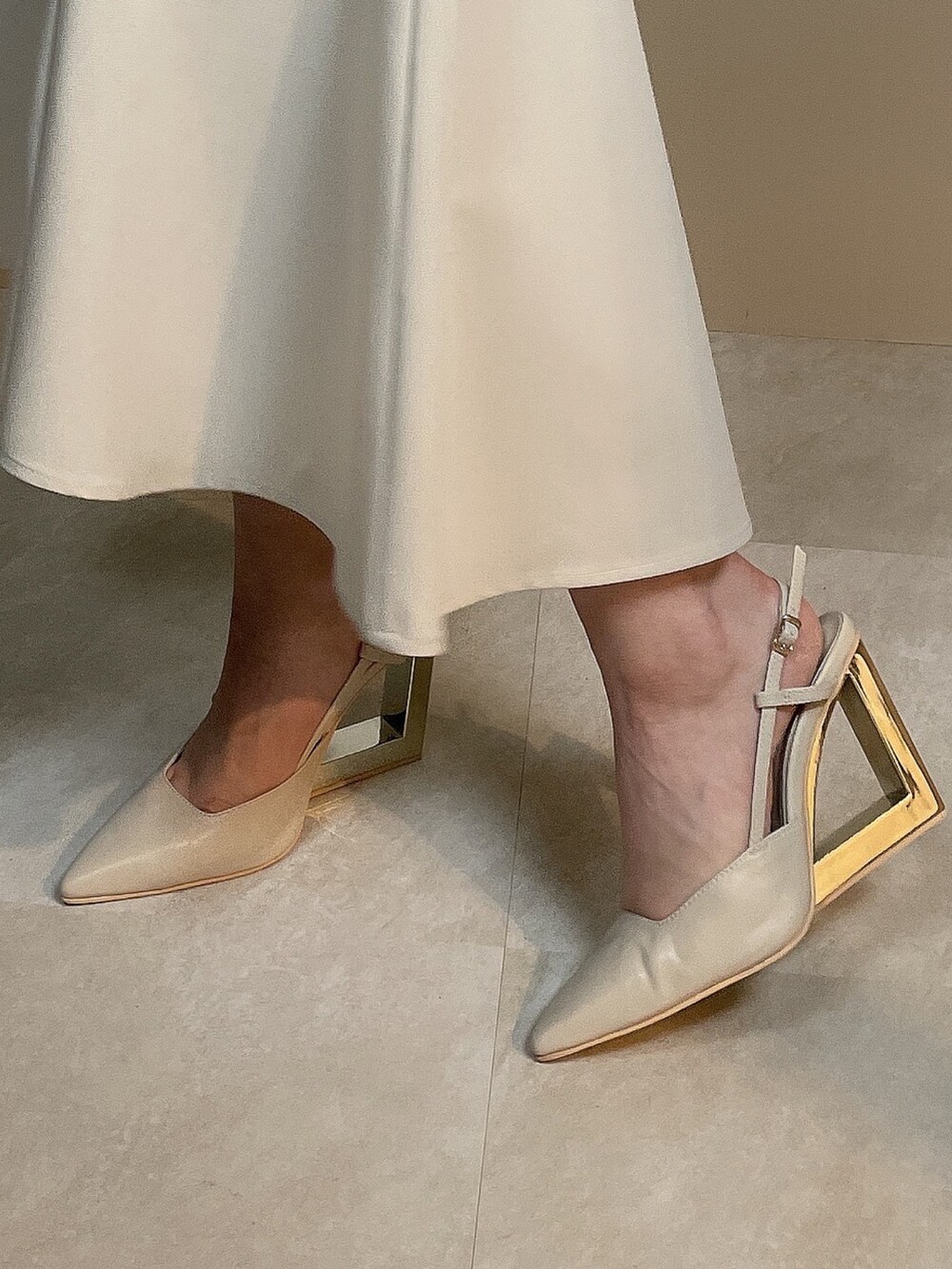 ホワイト系のライダースジャケット、ベージュ系のサンダル、ブルー系のワンピースを着用したレディースの夏コーディネートの8枚目の写真