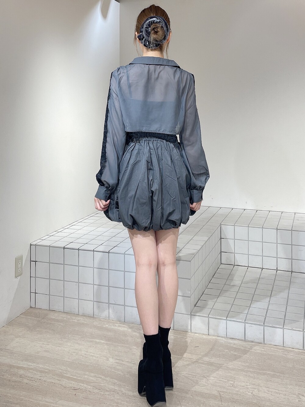 グレー系のワンピース、ブラック系のブーツ、グレー系のシュシュを着用したレディースの秋コーディネートの4枚目の写真