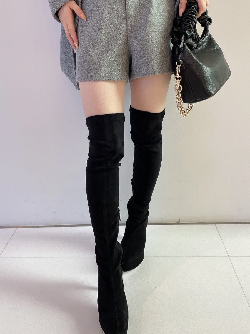 ブラック系のブーツ、グレー系のその他パンツ、ブラック系のハンドバッグを着用したレディースの秋コーディネートの7枚目の写真