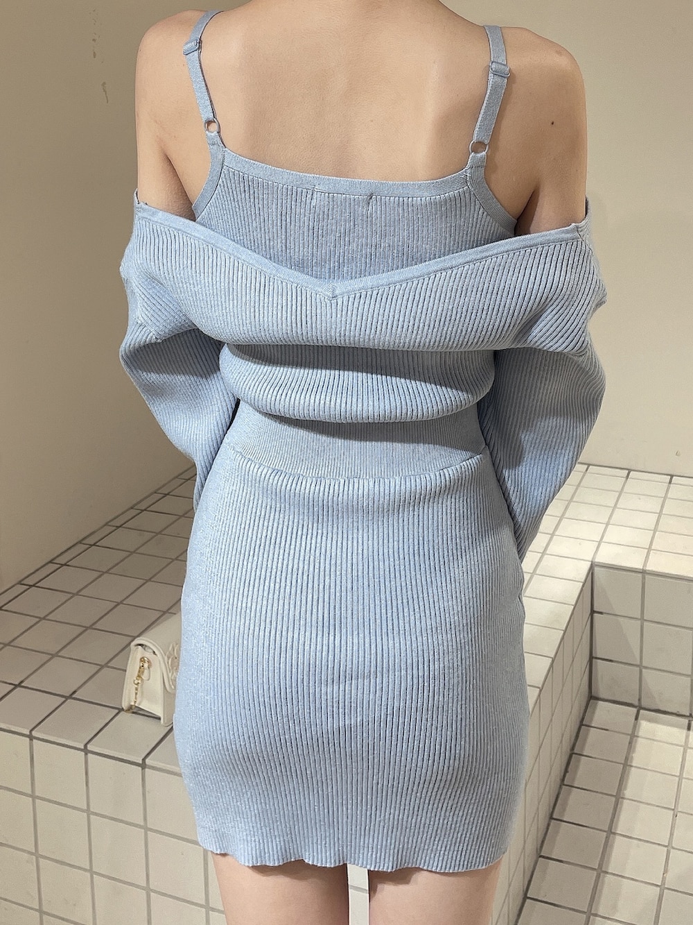 ブルー系のワンピース、ホワイト系のショルダーバッグ、ホワイト系のブーツを着用したレディースの冬コーディネートの6枚目の写真