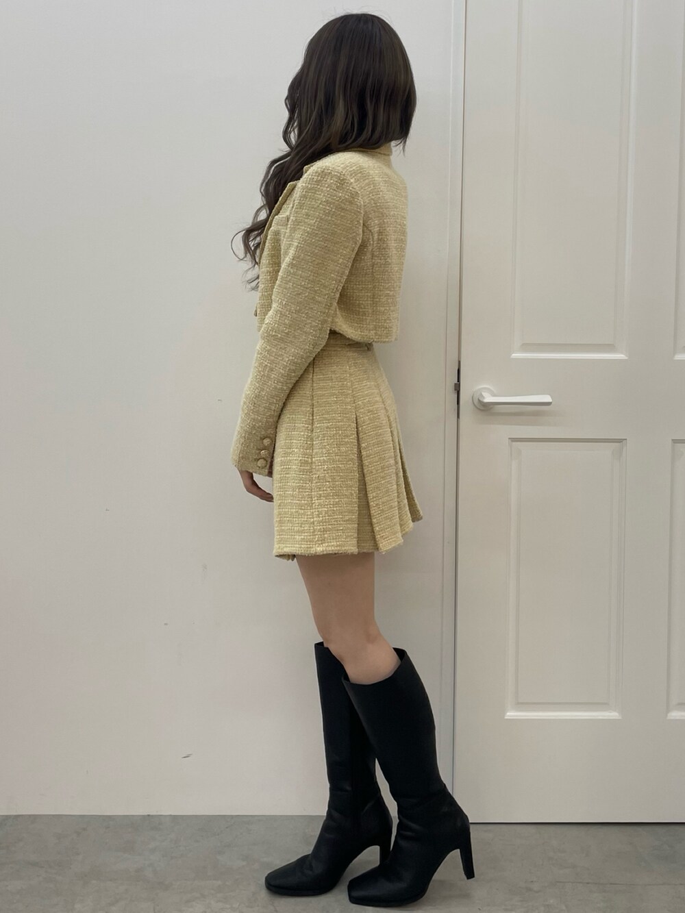 イエロー系のテーラードジャケット、イエロー系のスカート、ホワイト系のTシャツ/カットソーを着用したレディースの秋コーディネートの2枚目の写真