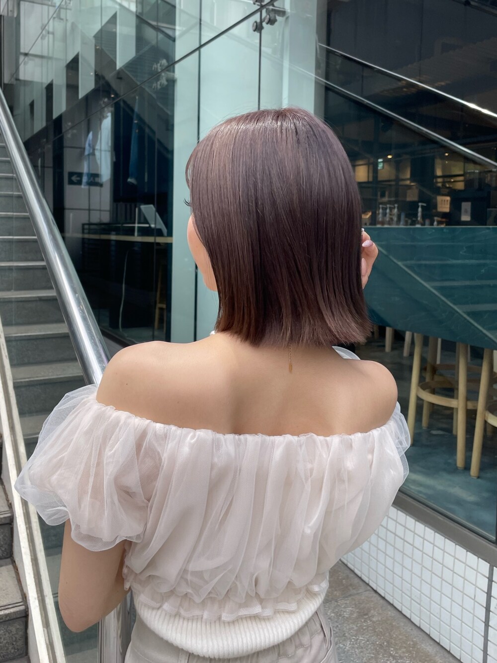 ホワイト系のシャツ/ブラウス、ベージュ系のスカート、ホワイト系のサンダルを着用したレディースの春コーディネートの6枚目の写真