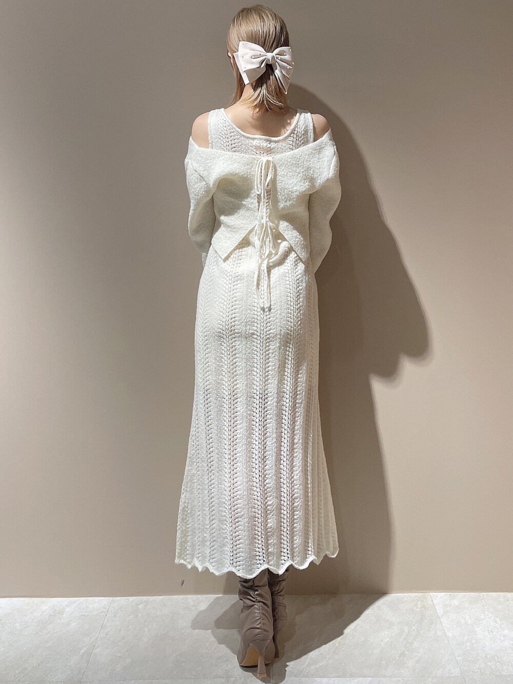 ホワイト系のブルゾン、ホワイト系のワンピース、ベージュ系のブーツを着用したレディースの秋コーディネートの6枚目の写真