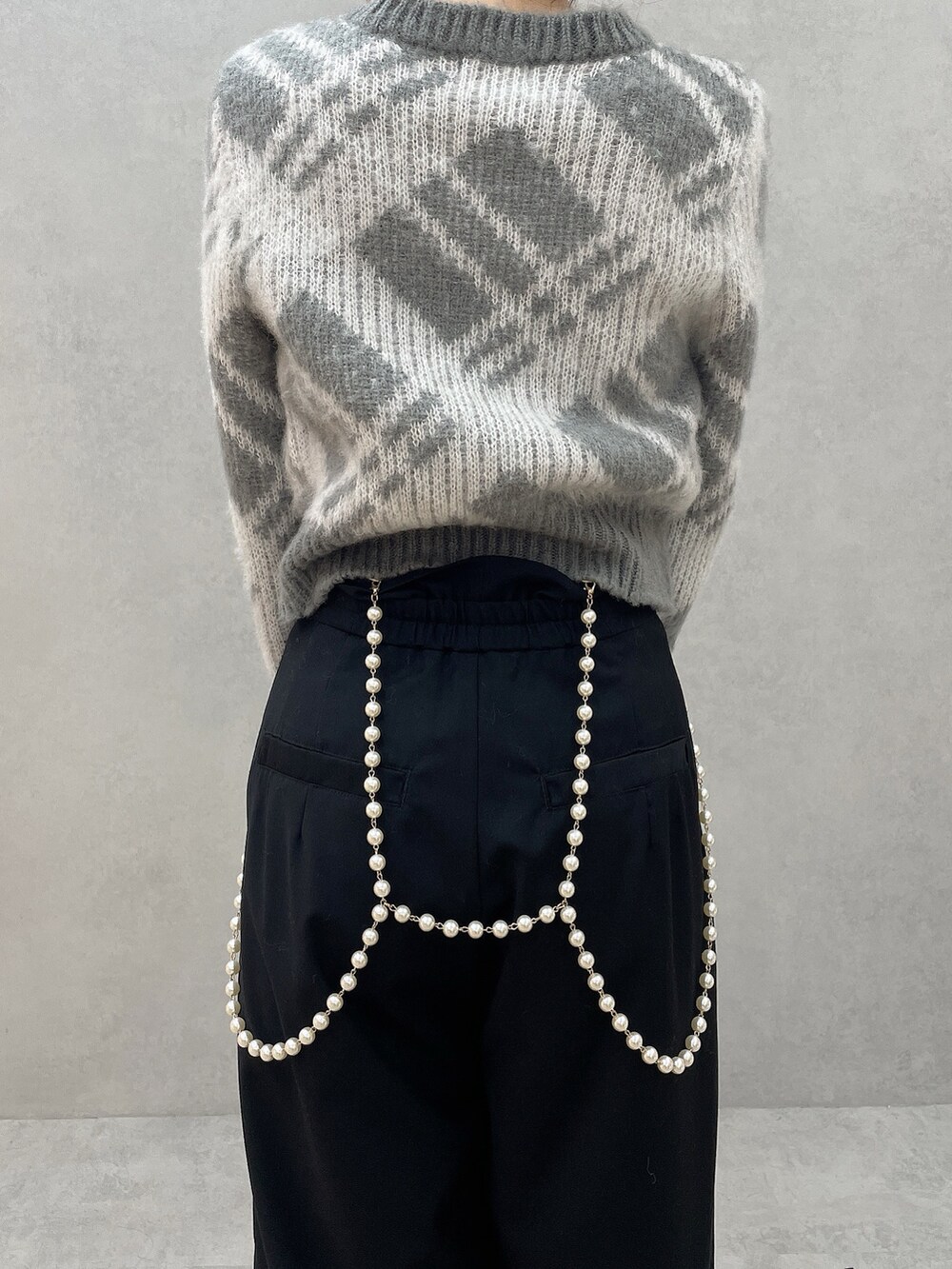 グレー系のニット/セーター、ブラック系のその他パンツ、ブラック系のブーツを着用したレディースの秋コーディネートの9枚目の写真