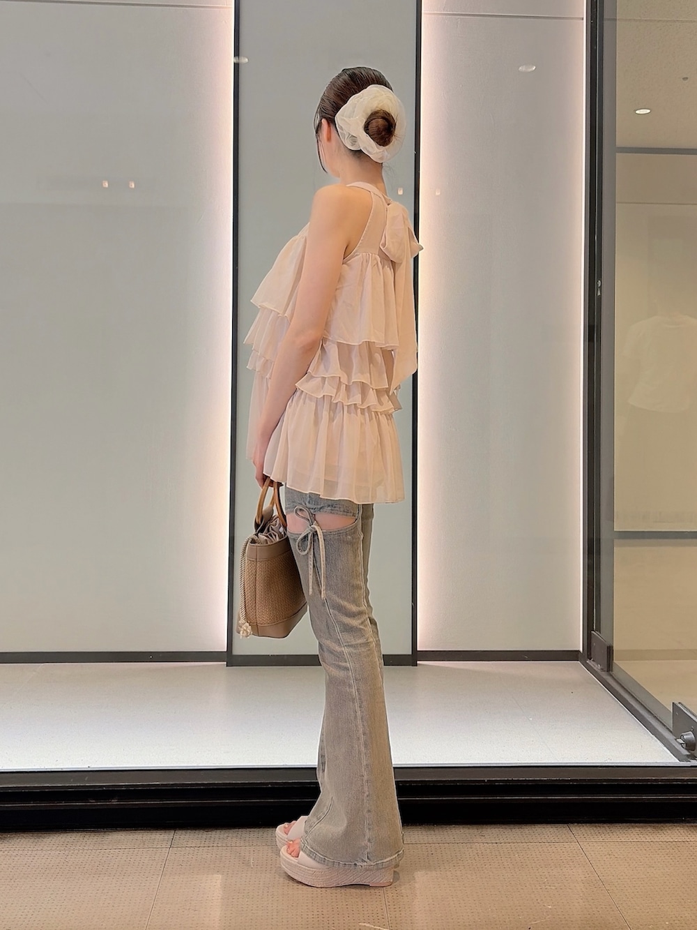 ホワイト系のシャツ/ブラウス、ブルー系のデニムパンツ、ベージュ系のハンドバッグを着用したレディースの夏コーディネートの3枚目の写真