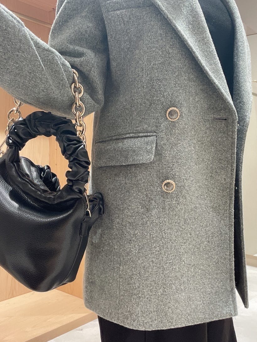 ブラック系のパンプス、グレー系のテーラードジャケット、ブラック系のハンドバッグを着用したレディースの秋コーディネートの4枚目の写真