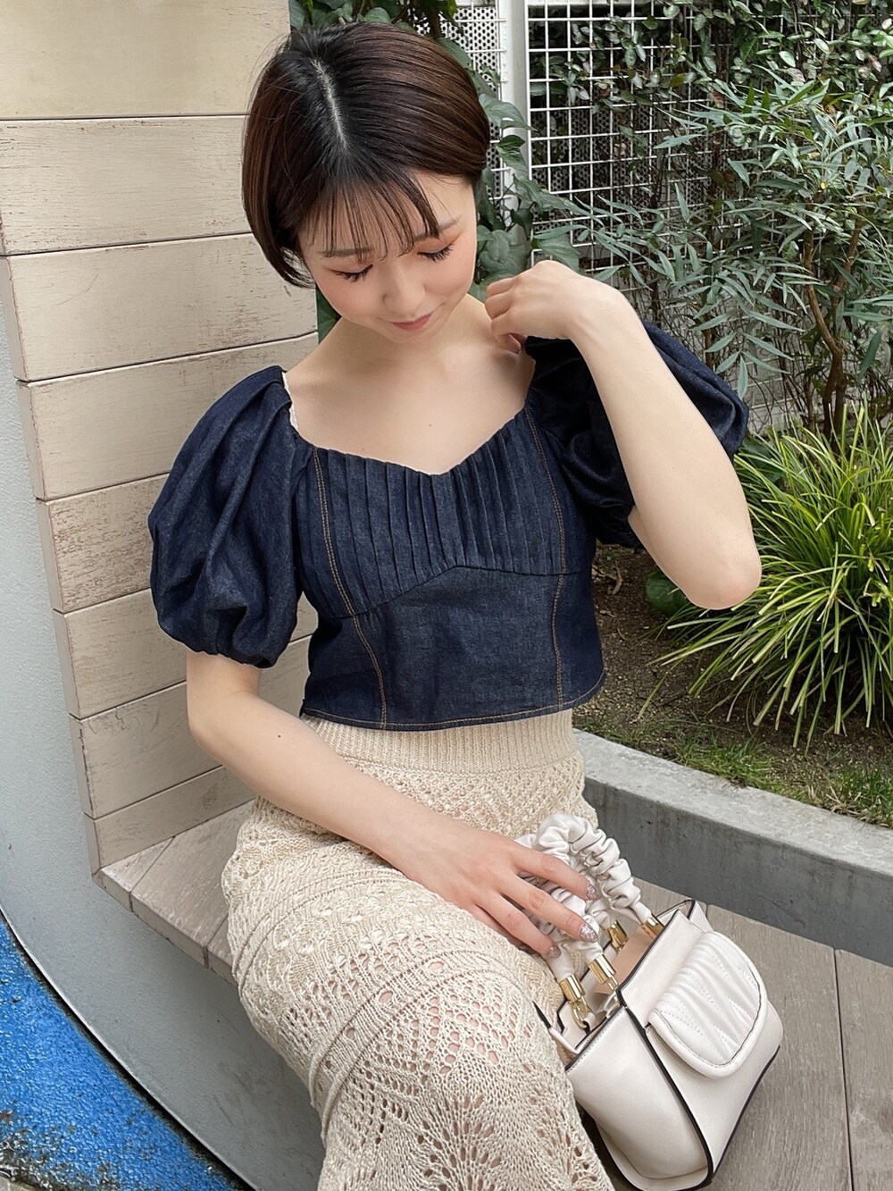 ホワイト系のサンダル、ホワイト系のハンドバッグ、ブルー系のシャツ/ブラウスを着用したレディースの春コーディネートの3枚目の写真