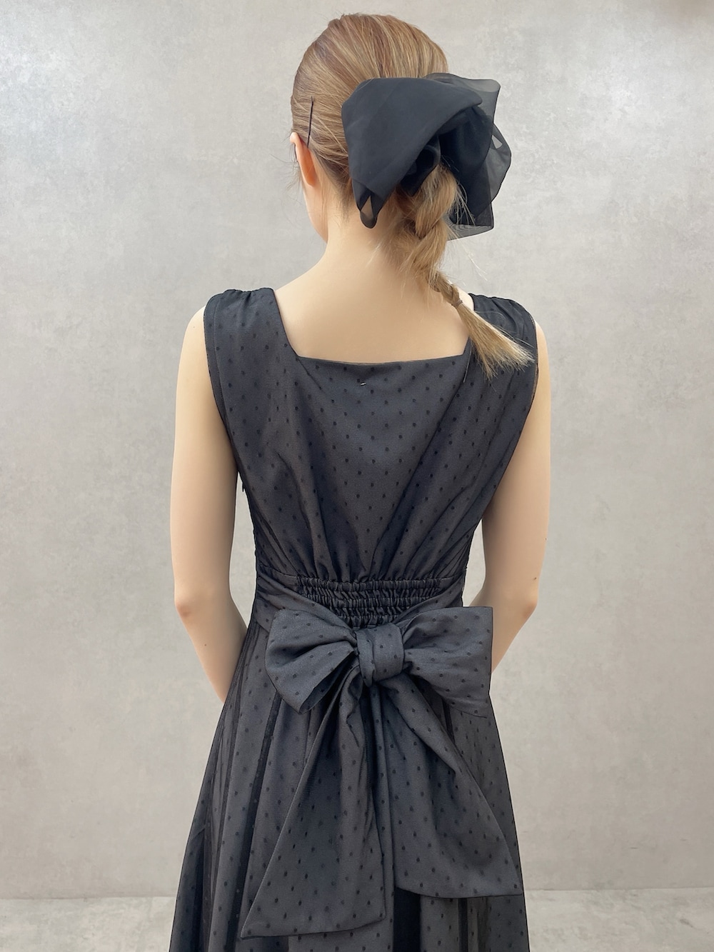 ブラック系のサンダル、ブラック系のワンピース、ブラック系のハンドバッグを着用したレディースの春コーディネートの6枚目の写真