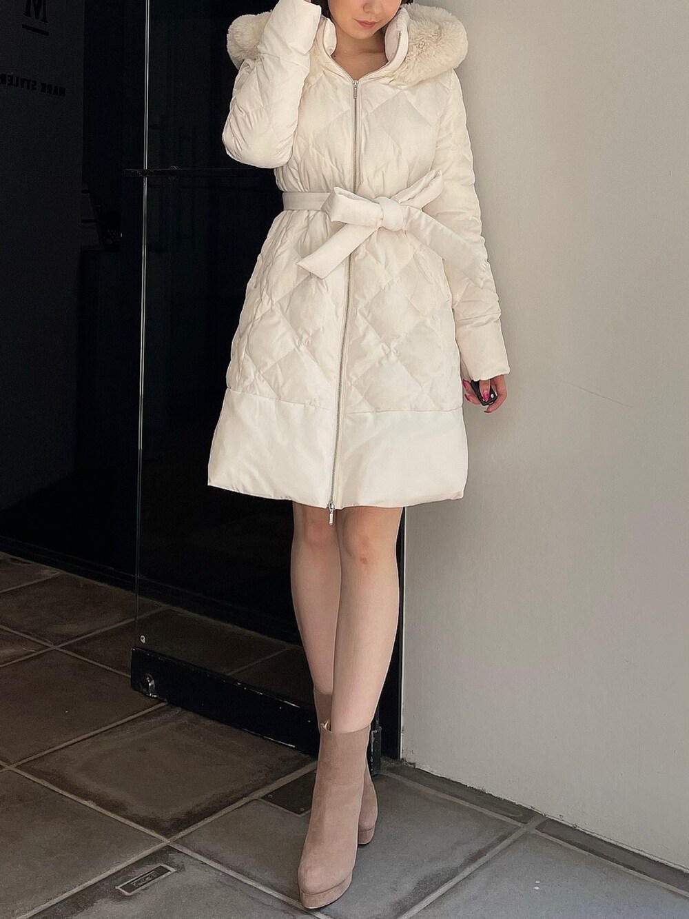 ベージュ系のブーツ、ホワイト系のダウンジャケット/コートを着用したレディースの夏コーディネートの2枚目の写真