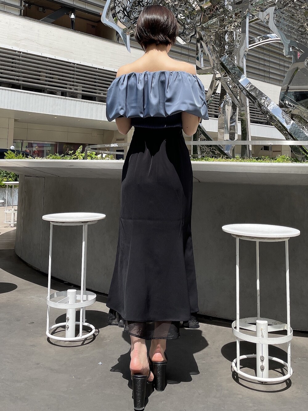 ブラック系のサンダル、ブルー系のニット/セーター、ブラック系のスカートを着用したレディースの春コーディネートの4枚目の写真