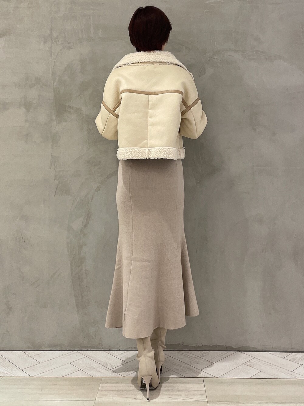 ホワイト系のワンピース、ホワイト系のブーツ、ホワイト系のブルゾンを着用したレディースの冬コーディネートの2枚目の写真