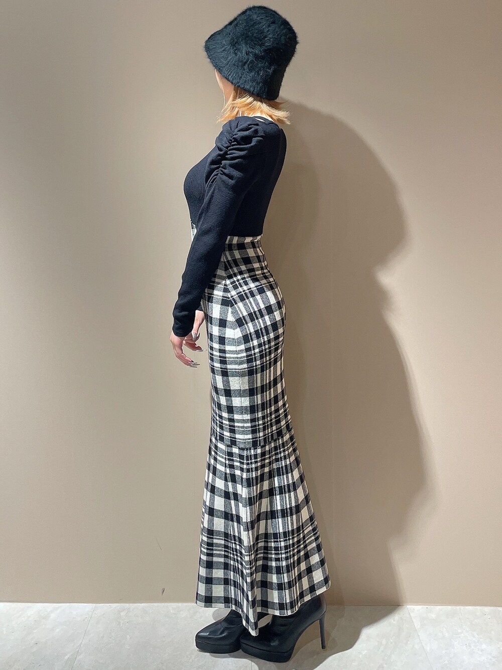 ブラック系のワンピース、ブラック系のブーツ、ブラック系のハットを着用したレディースの秋コーディネートの2枚目の写真