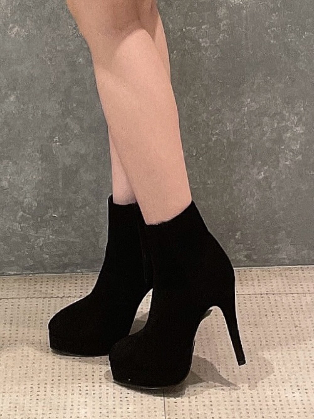 グリーン系のニット/セーター、ブラック系のスカート、ブラック系のブーツを着用したレディースの冬コーディネートの7枚目の写真