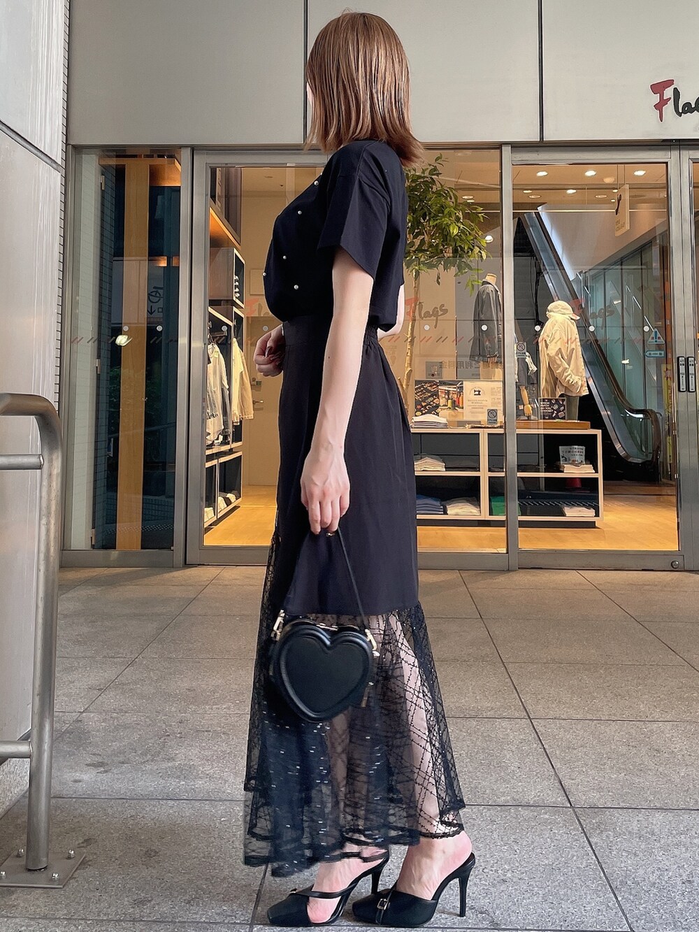 ブラック系のスリッポン、ブラック系のTシャツ/カットソー、ブラック系のスカートを着用したレディースの夏コーディネートの4枚目の写真