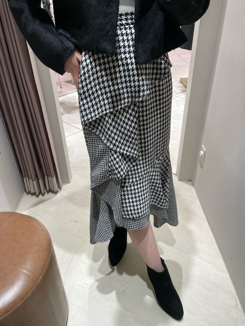 ブラック系のその他アウター、ホワイト系のニット/セーター、その他のスカートを着用したレディースの秋コーディネートの4枚目の写真