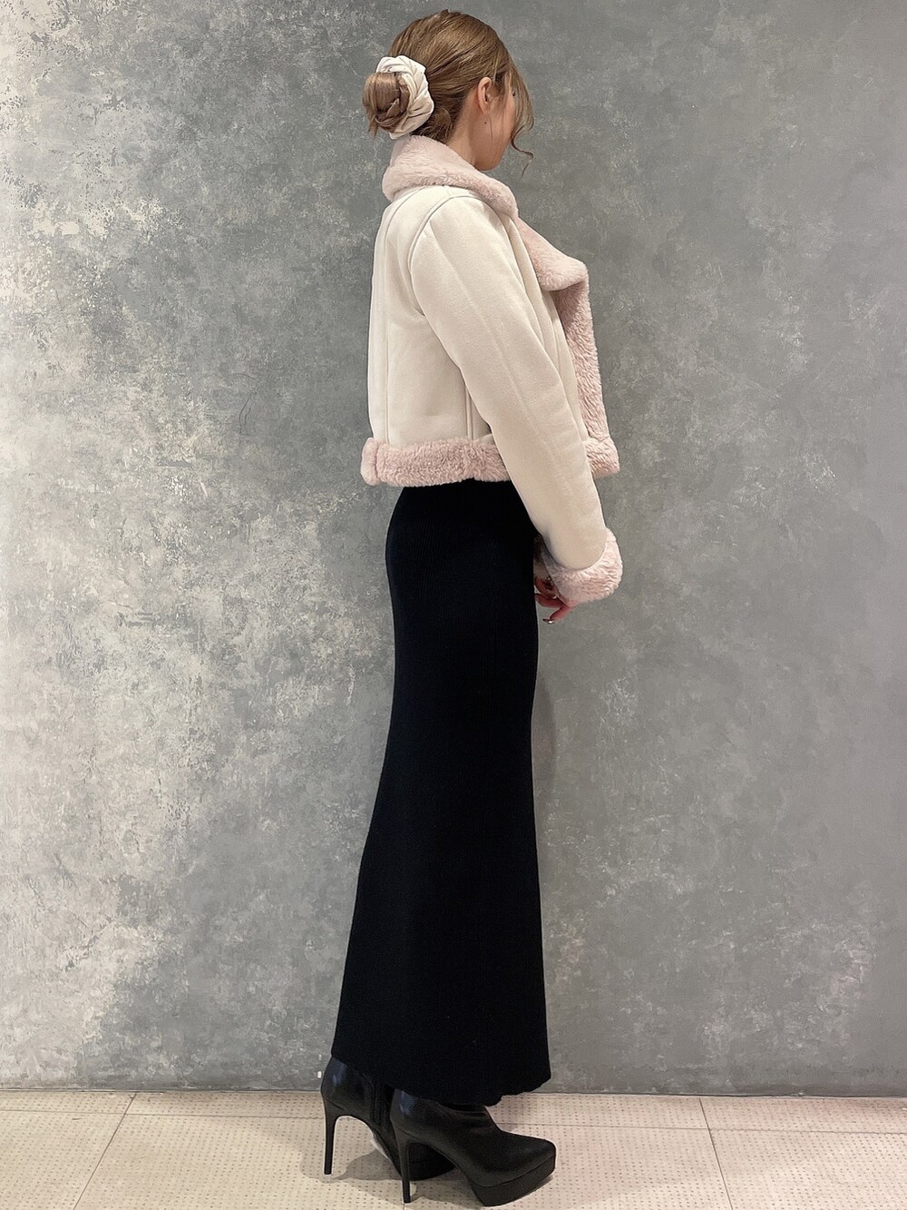 ベージュ系のブルゾン、ブラック系のワンピース、ブラック系のブーツを着用したレディースの秋コーディネートの2枚目の写真