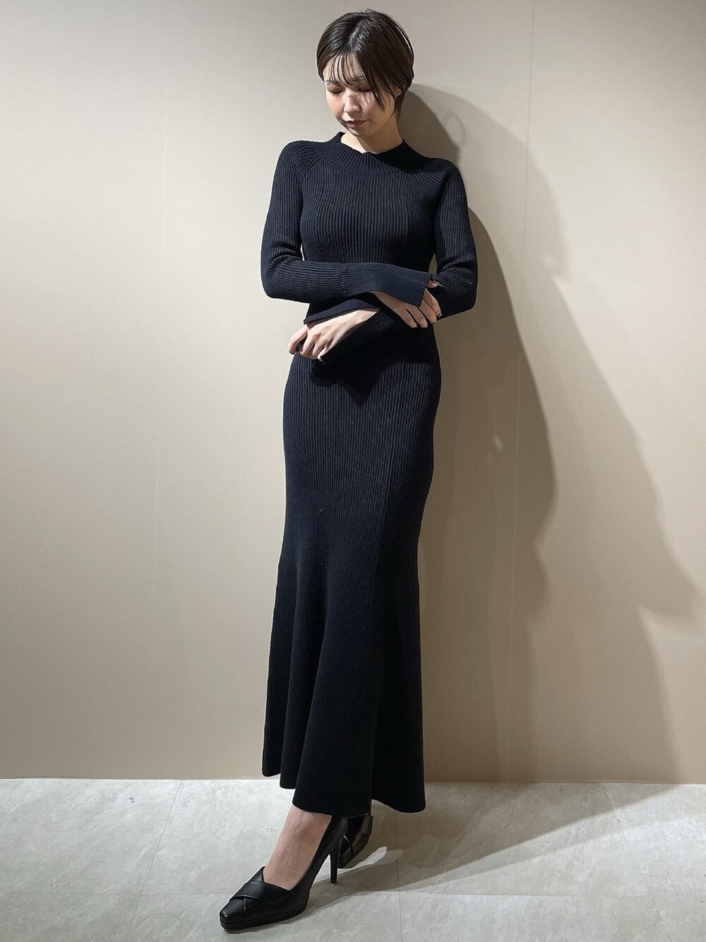 ブラック系のダウンジャケット/コート、ブラック系のワンピース、ブラック系のパンプスを着用したレディースの秋コーディネートの7枚目の写真