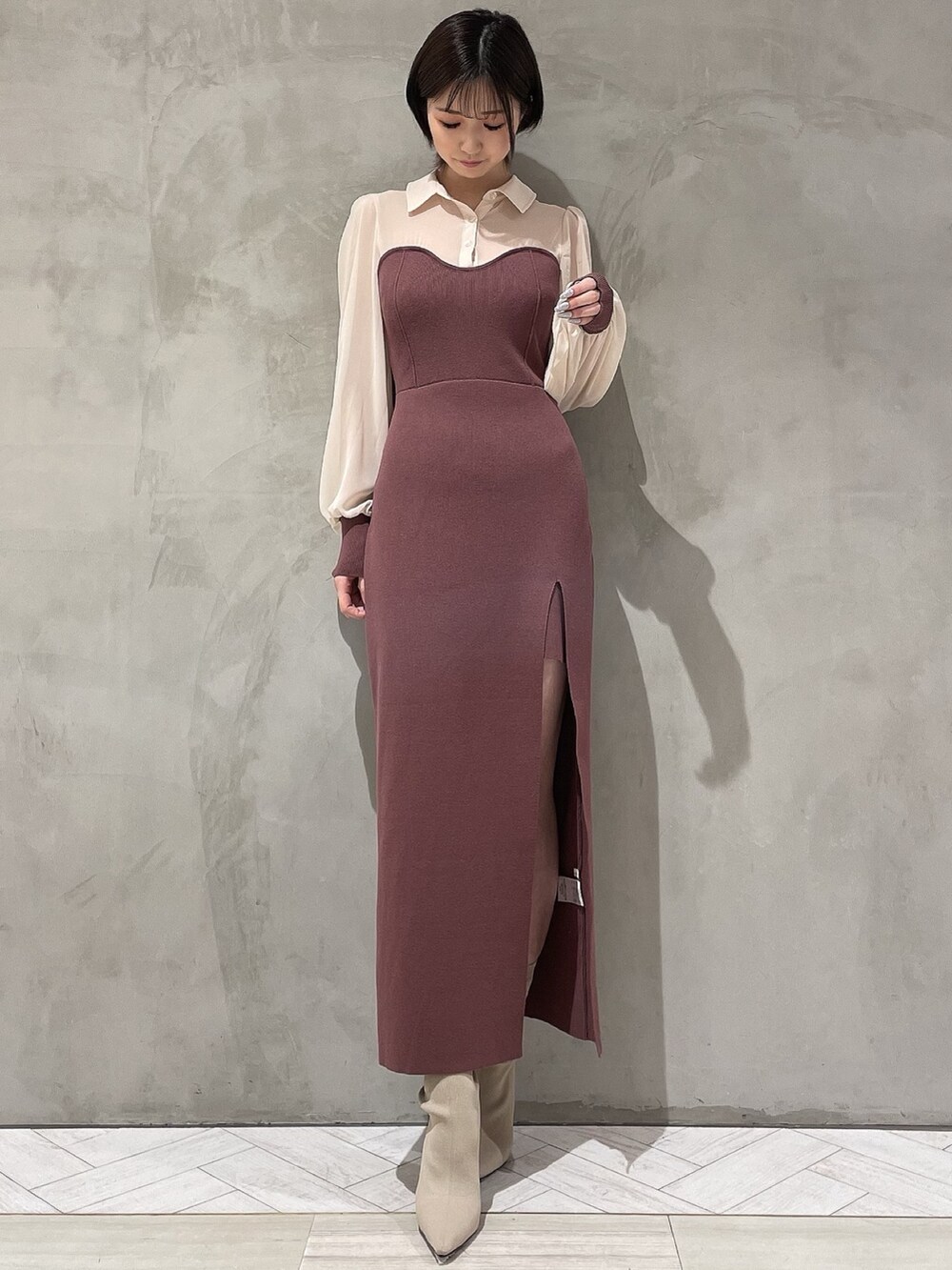 ベージュ系のトレンチコート、ブラウン系のワンピース、ホワイト系のブーツを着用したレディースの冬コーディネートの5枚目の写真