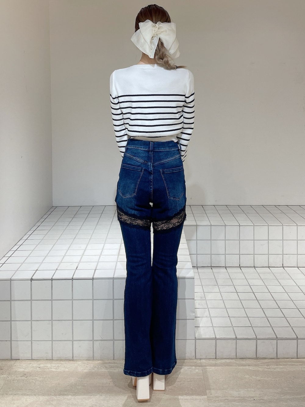 ホワイト系のカーディガン/ボレロ、ブルー系のデニムパンツ、ホワイト系のブーツを着用したレディースの春コーディネートの3枚目の写真