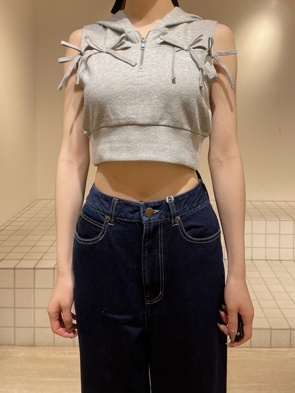 グレー系のパーカー、ブルー系のデニムパンツ、ブラック系のサンダルを着用したレディースの春コーディネートの4枚目の写真