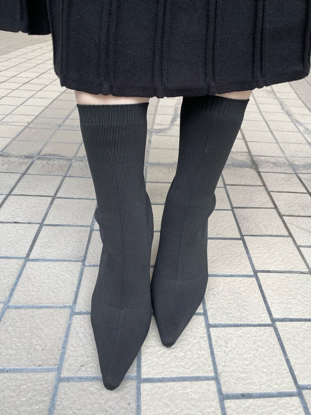 ブラック系のワンピース、ブラック系のブーツ、ブラウン系のハンドバッグを着用したレディースの秋コーディネートの10枚目の写真