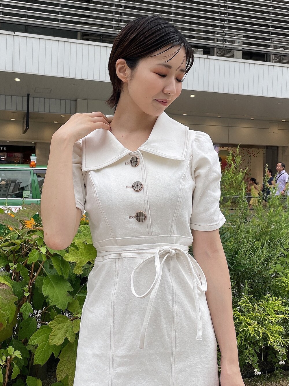 ホワイト系のワンピース、ホワイト系のハンドバッグ、ベージュ系のサンダルを着用したレディースの夏コーディネートの5枚目の写真