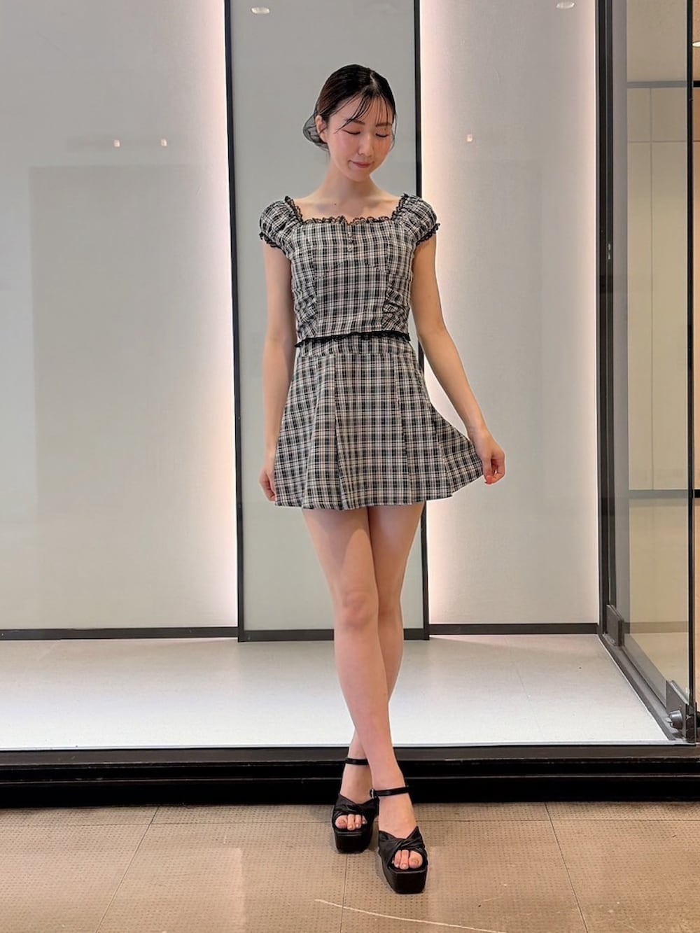 ブラック系のシャツ/ブラウス、ブラック系のスカート、ブラック系のサンダルを着用したレディースの夏コーディネートの2枚目の写真