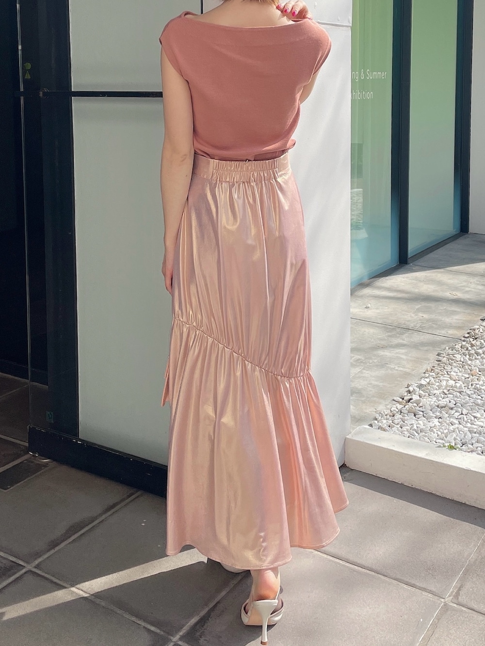 オレンジ系のニット/セーター、ゴールド系のスカート、ピンク系のハンドバッグを着用したレディースの春コーディネートの4枚目の写真